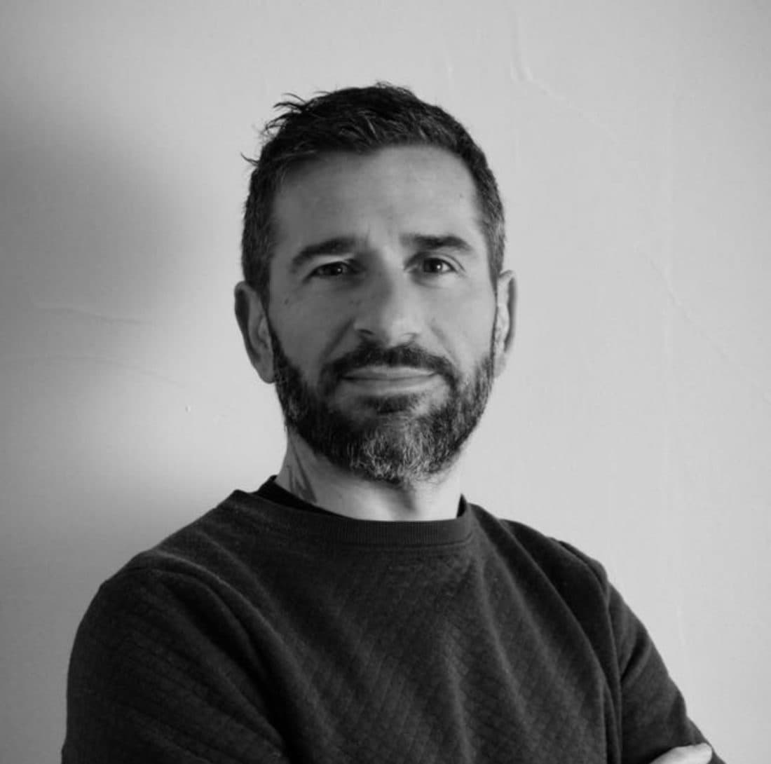 David, portrait en noir et blanc, barbe courte et pull sombre, regard vers l'objectif